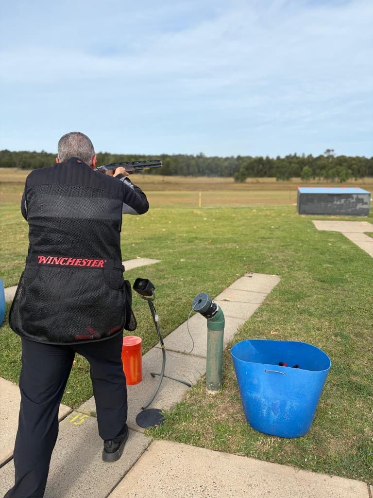 Shooter aiming at clay targets on the trap line during a grading day